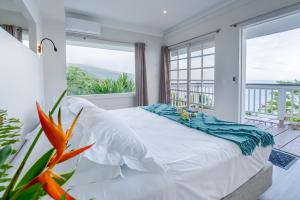 - une chambre avec un lit et une grande fenêtre dans l'établissement Toahotu estate one of a kind villa in Tahiti Iti pool and view - 15 pers, à Vairao