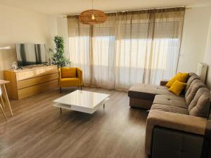 a living room with a couch and a coffee table at Harmonieux/Bezannes/Pkg Privé in Bezannes-les-Reims