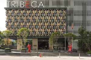 a building with two people walking in front of it at Tribeca Serviced Hotel by Millennium in Kuala Lumpur