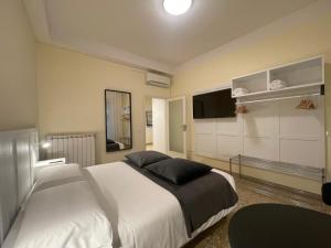 - une chambre avec un grand lit blanc et une télévision à écran plat dans l'établissement YOME-GUICCIARDINI 10, à Florence