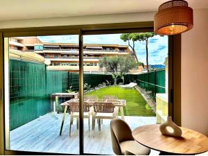 a balcony with a table and chairs and a large window at Riviera in Cagnes-sur-Mer