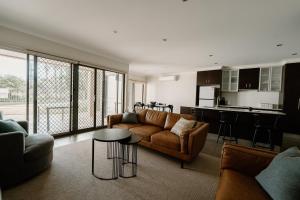 a living room with a couch and a table at Yarrawonga Waterfront Apartments in Mulwala
