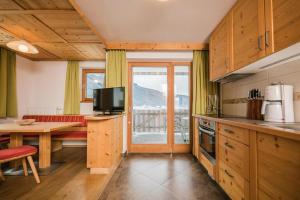 a kitchen with a table and a couch and a television at Pichlerhof Apt 3 in Valle Di Casies