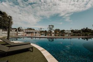 a large swimming pool with a chair and a building at Yarrawonga Waterfront Apartments in Mulwala