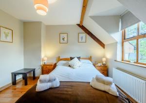 a bedroom with a bed with two white towels on it at Chestnut Cottage in Manorbier