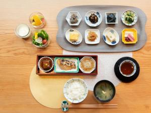 una mesa con platos de comida y tazones de comida en Mitsui Garden Hotel Nihonbashi Premier, en Tokio