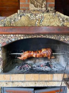 un morceau de viande préparé dans un four en briques dans l'établissement Mini 2 apartmani Nature Connection Drina, à Bajina Bašta