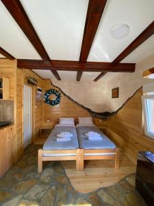 1 dormitorio en una cabaña de madera con 1 cama en Mini 2 apartmani Nature Connection Drina, en Bajina Bašta