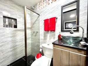 uma casa de banho com um WC e um lavatório de vidro em Edificio Victory Medellin - Apartamentos Acogedores y Equipados 100MB Wi-Fi, Central & Terraza Compartida em Medellín