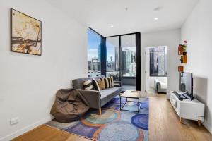 a living room with a couch and a tv at Central 15th floor Apt near Flagstaff & QV Market in Melbourne