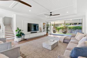 a living room with a couch and a tv at Orana Byron in Byron Bay