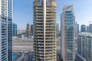 a tall building in a city with tall buildings at Charming 1 Bedroom - Close to Metro in Dubai