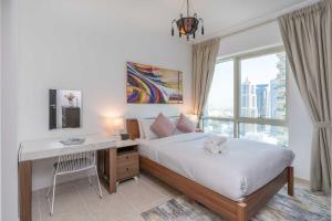 a bedroom with a bed with a desk and a window at Charming 1 Bedroom - Close to Metro in Dubai