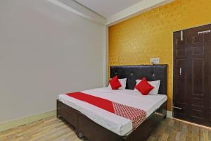 - une chambre avec un lit doté d'oreillers rouges dans l'établissement OYO Flagship Relax Stay In, à Lucknow