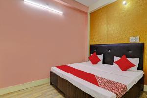- une chambre avec un lit doté d'oreillers rouges dans l'établissement OYO Flagship Relax Stay In, à Lucknow