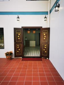 a hallway with doors and a red tile floor at Tranquera House in Ranau