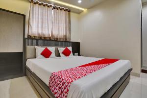 1 dormitorio con 1 cama grande con almohadas rojas en Hotel Dhiman Residency en Bombay