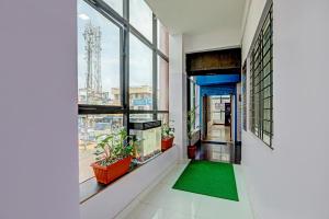 a hallway with windows and a green rug at Super Collection O Emara Grand Mysore in Mysore