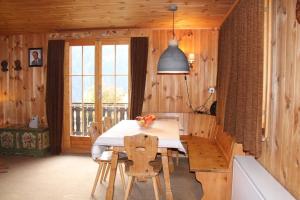 a dining room with a table and chairs and a window at Freude am Berg in Malix