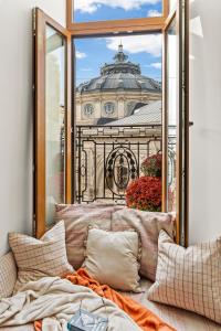 d'un canapé en face d'une fenêtre offrant une vue sur le bâtiment. dans l'établissement 2 Bedroom Apartment - Romanian Athenaeum, à Bucarest