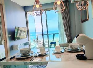 a dining room with a table with a view of the ocean at 芭提雅高层海景奢华公寓The Riviera Jomtien生香家直达海滩23 in Jomtien Beach