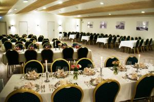 a banquet hall with tables and chairs in a room at Hotel Falken in Videbæk