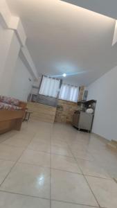 a large room with a white tile floor and a room with windows at Nektar-apartments in Piraeus