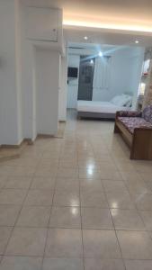 a room with a tiled floor with a couch at Nektar-apartments in Piraeus
