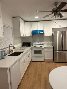 una cocina con armarios blancos y electrodomésticos de acero inoxidable en Guest House Casa De Thousand Oaks, en Thousand Oaks