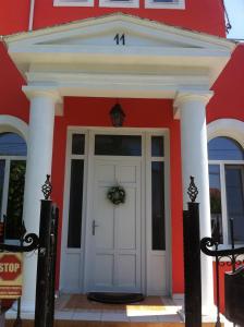 a red and white building with a white door at Villa Favorita in Eforie Sud