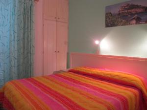 a bedroom with a bed with a colorful blanket at Aparthotel Villa Marinù in Ischia