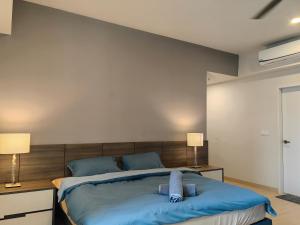 una camera da letto con un grande letto blu con due lampade di Windmill Upon Hills, Genting Highlands a Resorts World Genting
