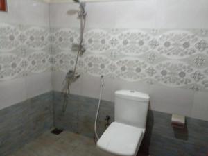 a bathroom with a white toilet and a shower at Ella Eco Adventure Point in Bandarawela