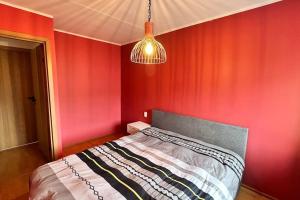 Un dormitorio con una pared roja y una cama. en Only 5 min. From Tallinn Airport, en Petrikyula
