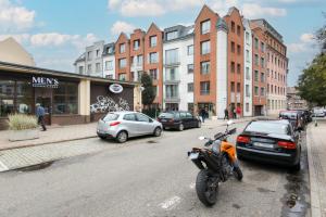 a motorcycle parked on the side of a city street at Stylish studio in modern design - Tartaczna 2 by Rent like home in Gdańsk