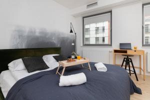 a bedroom with a large bed with a table on it at Stylish studio in modern design - Tartaczna 2 by Rent like home in Gdańsk