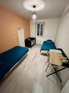 a bedroom with a blue bed and a table at Havre de tranquillité à 13Kms des plages de Royan in Le Gua