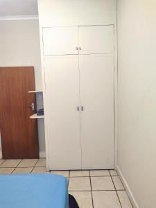 a white closet with white cabinets in a room at Zulia home in Pretoria