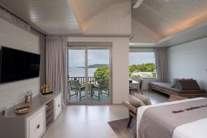 a bedroom with a bed and a view of the ocean at Rocky's Boutique Resort - Veranda Collection Samui in Lamai