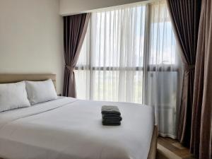 een slaapkamer met een bed en een groot raam bij Căn hộ cao cấp Metropole in Ho Chi Minh-stad