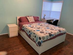 1 dormitorio con cama, escritorio y ventana en Tehama Home - Cozy & Affordable Private Rooms near Berkeley, en Richmond