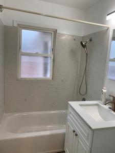 baño con bañera, lavabo y ventana en Tehama Home - Cozy & Affordable Private Rooms near Berkeley, en Richmond