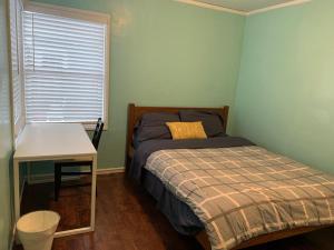 1 dormitorio con cama, mesa y ventana en Tehama Home - Cozy & Affordable Private Rooms near Berkeley, en Richmond