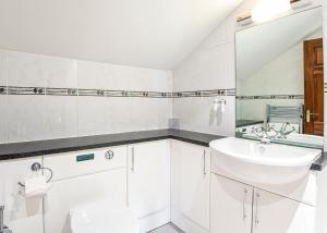 a white bathroom with a sink and a toilet at Green Acres Cottages in Par