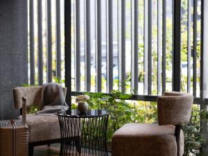 Zimmer mit 2 Stühlen und einem Tisch vor einem Fenster in der Unterkunft Mitsui Garden Hotel Fukuoka Nakasu in Fukuoka