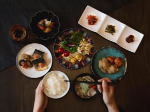 a person eating food on a table with plates of food at Mitsui Garden Hotel Fukuoka Nakasu in Fukuoka