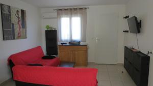 a living room with a red couch and a television at Jason in Cervione
