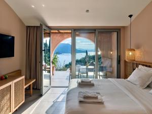 a bedroom with a large bed and a view of the ocean at ISAVORIA ECO CHIC RESORT in Parga