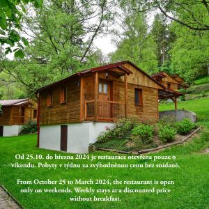 a small wooden house with a sign in front of it at Letovisko Chobot - village resort in Kácov