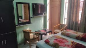 - une chambre avec un lit, une table et un miroir dans l'établissement Hotel Rajmahal, Rudrapur, à Rudrapur